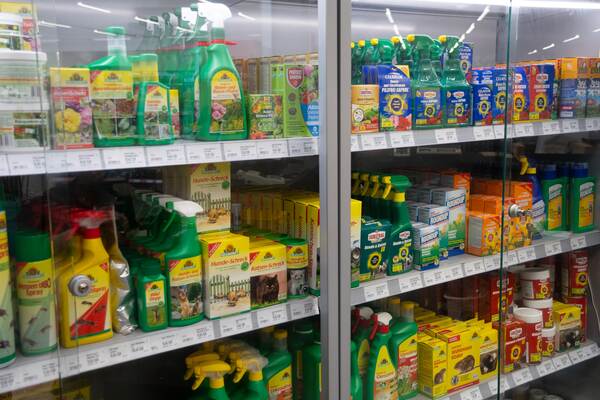 Du siehst ein Regal im Raiffeisen-Markt mit Pflanzenschutzmitteln, Dünger und Unkrautvernichter.